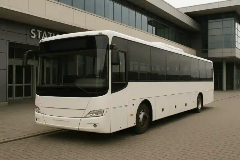 Autobús blanco estacionado frente a una estación de tren, ofreciendo servicio alternativo de viajeros.
