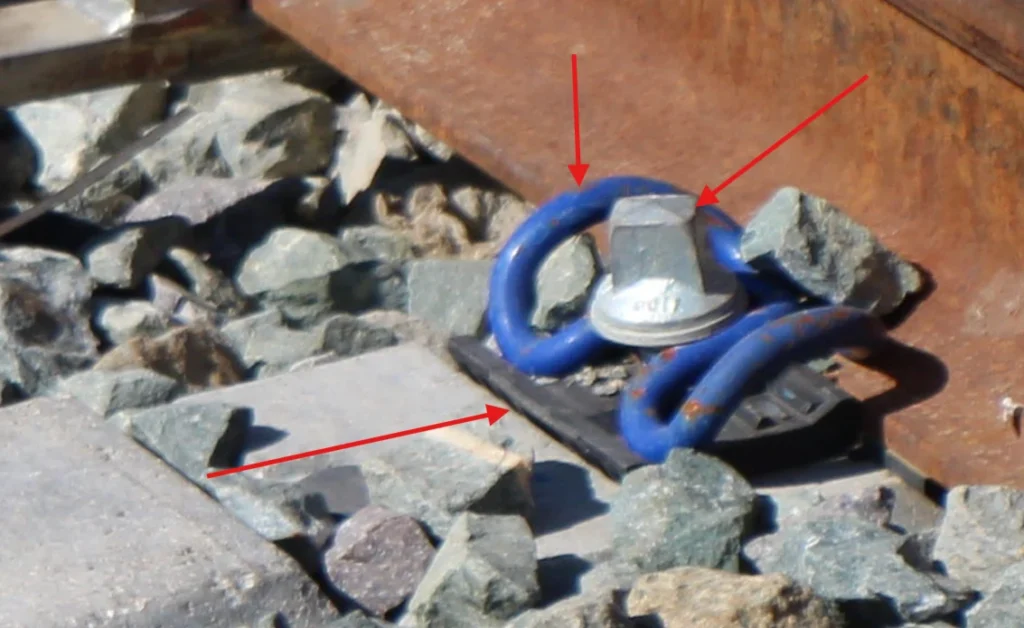 Detalle de los elementos de sujeción de vía, señaladas con flechas.