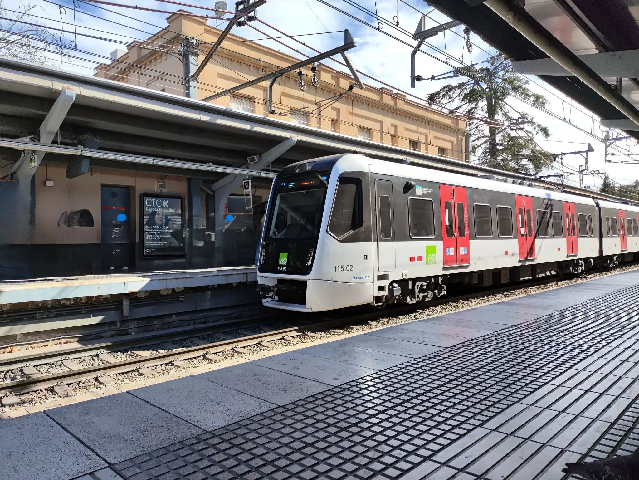 Tren de Ferrocarrils de la Generalitat de Catalunya llegando al andén de una estación