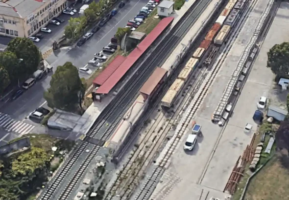 Vista aérea de la estación de viajeros de Ariz-Basauri, mostrando los andenes con marquesinas rojas, las vías de paso y una zona de carga en el lateral derecho.
