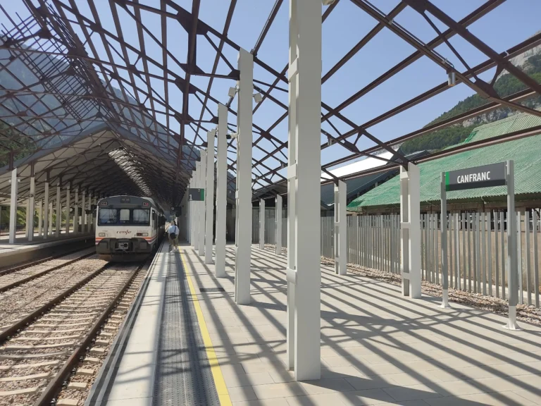 Un automotor de la serie 596 de Renfe estacionado en la vía 1 bajo la marquesina metálica de la estación de Canfranc, en la histórica Línea de Canfranc.