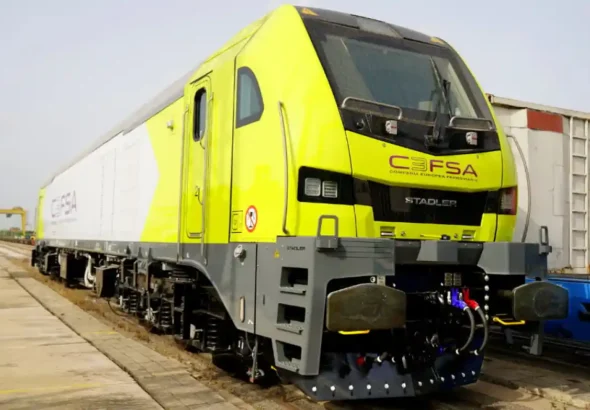 Vista frontal de una locomotora eléctrica Stadler Euro 6000 de color amarillo fluorescente y gris con el logotipo de CEFSA en una vía de carga.