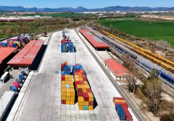 Vista aérea de la renovada terminal logística de Noaín con contenedores intermodales de varios colores ordenados en la explanada de hormigón y vías de tren a los lados.