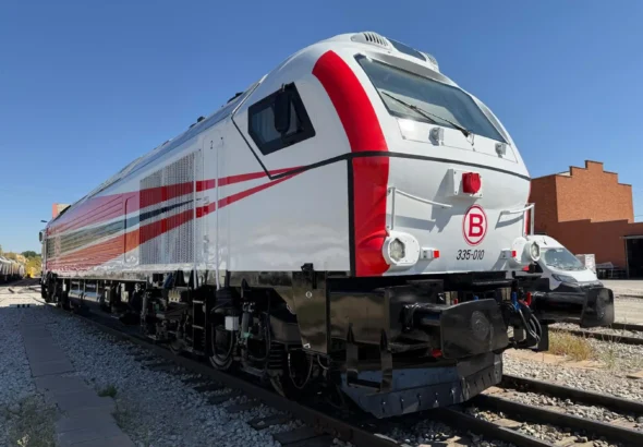 Locomotora diésel-eléctrica de mercancías modelo Euro 4000 (matrícula 335-010) de color blanco con franjas rojas y negras, estacionada sobre las vías en un día despejado.