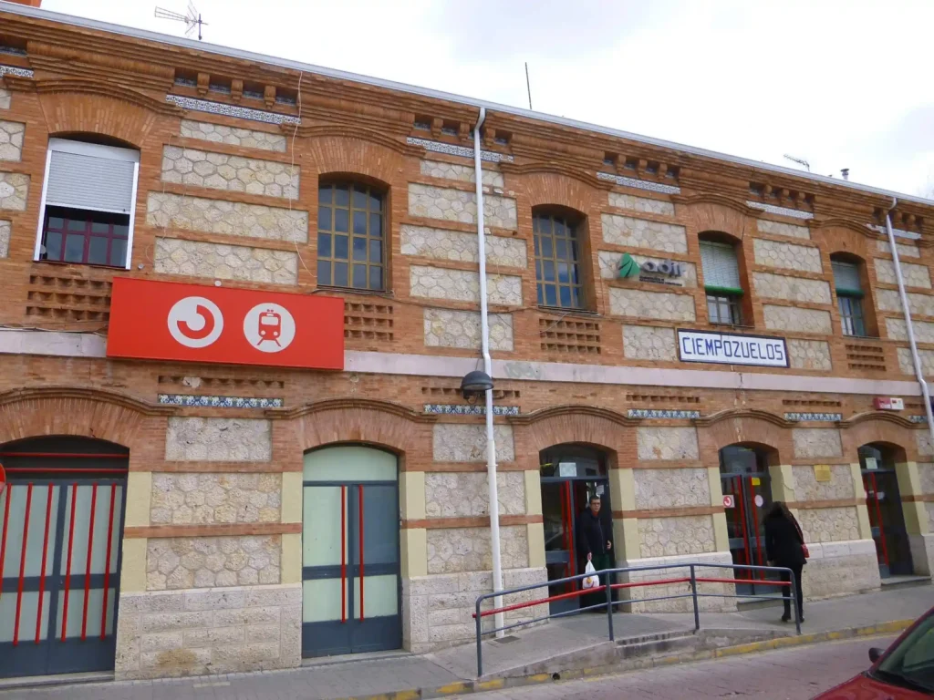 Fachada de ladrillo visto y piedra de la estación de tren de Cercanías de Ciempozuelos, con los carteles identificativos de Adif y Cercanías, y una rampa de acceso en la entrada.