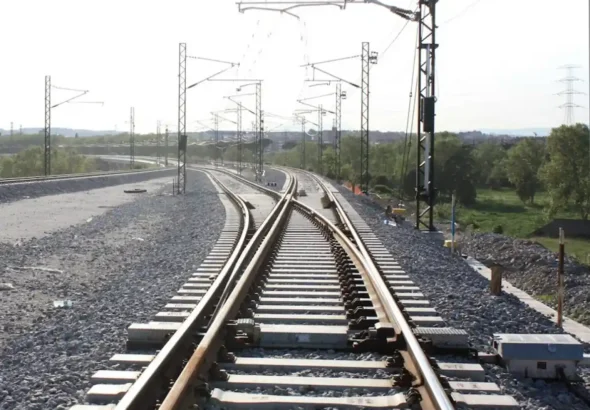 Tramo de vía ferroviaria con sistema de tres carriles para ancho mixto e infraestructura de catenaria al aire libre en Mollet.