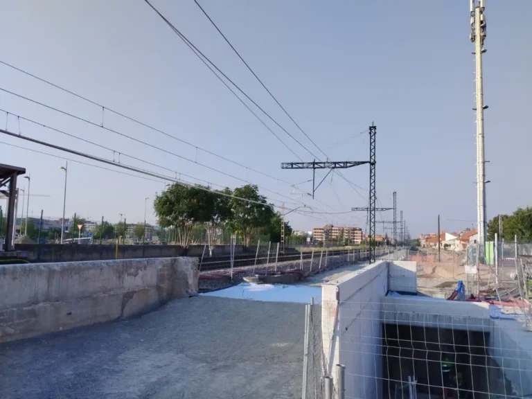 Vista panorámica de una zona de obras en el trazado ferroviario, con estructuras de hormigón, catenarias, postes de electrificación y vallas de seguridad para la ampliación de la línea de alta velocidad.