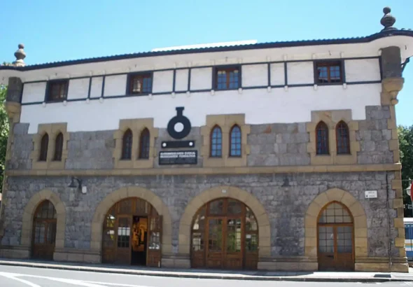 Fachada exterior del edificio histórico del Museo Vasco del Ferrocarril en Azpeitia, construido en piedra de sillería con grandes arcos en la planta baja y entramado visto en la parte superior.