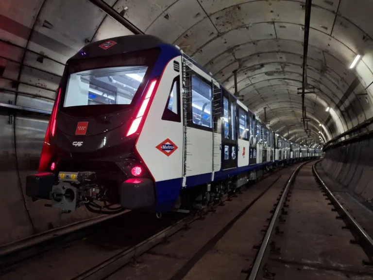 Nuevo tren automático de CAF para la Línea 6 de Metro de Madrid, pintado en blanco, azul y rojo, realizando pruebas nocturnas en un túnel iluminado.