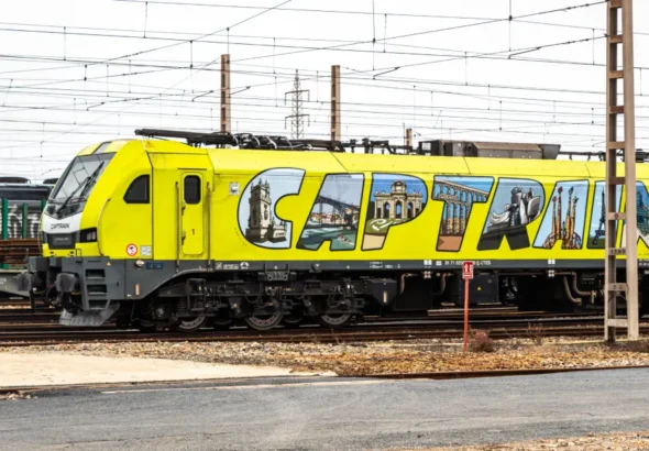 Locomotora eléctrica Stadler EURO6000 de Captrain, ejemplo de la renovación del material rodante ferroviario de mercancías, estacionada sobre vías electrificadas.