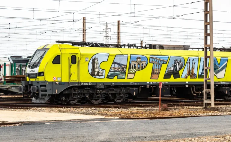 Locomotora eléctrica Stadler EURO6000 de Captrain, ejemplo de la renovación del material rodante ferroviario de mercancías, estacionada sobre vías electrificadas.