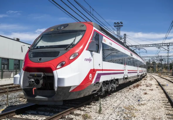 Tren Civia de Cercanías Renfe de colores blanco, rojo y morado estacionado sobre las vías de la red ferroviaria bajo un cielo despejado. los cortes en el túnel de sol son para realizar un nuevo esquema de vías.